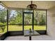 Enclosed lanai featuring a ceiling fan, tiled flooring, and peaceful views of the backyard at 1101 2Nd Ave. N # 1501, Surfside Beach, SC 29575