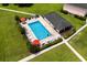 Aerial view of a community pool with lounge chairs, surrounded by a green lawn and walkway at 1101 2Nd Ave. N # 1501, Surfside Beach, SC 29575