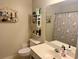 Bathroom featuring Hello Kitty shower curtain, white sink and toilet and three storage shelves at 112 Palisade Loop # 112, Pawleys Island, SC 29585