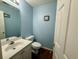 Powder room with blue walls, vanity with a sink, toilet, and decorative accents at 112 Palisade Loop # 112, Pawleys Island, SC 29585
