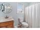 Bright bathroom featuring a wood vanity, toilet, window, and a shower with curtain at 121B 7Th Ave. S, Surfside Beach, SC 29575