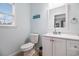 Bright bathroom with a single vanity, window, and all white toilet at 121B 7Th Ave. S, Surfside Beach, SC 29575