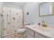 A bathroom featuring a shower with patterned curtain, toilet, sink with gold faucet, and a mirror at 121B 7Th Ave. S, Surfside Beach, SC 29575