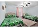 Bright bedroom featuring two twin beds with tropical leaf comforters, wood floors and a ceiling fan at 121B 7Th Ave. S, Surfside Beach, SC 29575