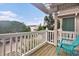This porch has wood floors, a white railing, a blue chair, and a view to the street at 121B 7Th Ave. S, Surfside Beach, SC 29575