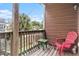 Relaxing porch with a red chair, a table, wood floors, a wood railing, and a view to the backyard at 121B 7Th Ave. S, Surfside Beach, SC 29575