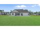Back of home and expansive lawn showcasing a covered patio and black metal fencing at 1253 Kenworth Circle, Conway, SC 29526