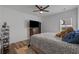 Well-lit bedroom showcasing a ceiling fan, wood-look flooring, TV, and cozy bedding at 1253 Kenworth Circle, Conway, SC 29526