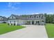 Charming two-story home with a manicured lawn, black roof, white exterior and inviting front porch at 1253 Kenworth Circle, Conway, SC 29526