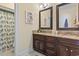 Bathroom featuring double sink granite vanity, dark wood cabinets, and decorative mirrors at 157 Pottery Landing Dr., Conway, SC 29526