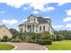 Elegant home featuring landscaped yard with staircase and fountain, leading up to a column-lined porch and balcony at 157 Pottery Landing Dr., Conway, SC 29526