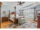 Spacious main bedroom featuring wooden floors, large windows and a four-poster bed with high end decor at 157 Pottery Landing Dr., Conway, SC 29526