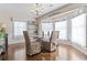 Elegant dining room featuring hardwood floors, a glass table, decorative lighting, and large windows at 1575 Victoria Ln., Myrtle Beach, SC 29577