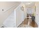Hallway with hardwood floors, white stairs, and neutral colored walls leading to other rooms at 1575 Victoria Ln., Myrtle Beach, SC 29577