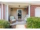 Inviting front porch with seating area, decorative pineapple sconces, and fresh wreath at 158 Palisade Loop # 158, Pawleys Island, SC 29585