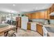 Eat-in kitchen featuring wood cabinets, white appliances, and an adjacent dining area with backyard views at 158 Palisade Loop # 158, Pawleys Island, SC 29585
