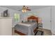 Cozy bedroom featuring a ceiling fan, window shutters, and wood-look floors at 175 Cypress Ln., Little River, SC 29566