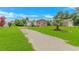 Charming brick home features a well-kept lawn, a gravel driveway, and mature trees at 175 Cypress Ln., Little River, SC 29566