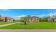 Brick home features a lush green lawn with a charming palm tree and traditional design at 175 Cypress Ln., Little River, SC 29566