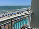 Balcony view of beach and pool with blue umbrellas and ocean views at 201 S Ocean Blvd. # 408, Myrtle Beach, SC 29577