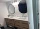 Bathroom vanity featuring dual sinks, modern faucets, and round mirrors at 201 S Ocean Blvd. # 408, Myrtle Beach, SC 29577