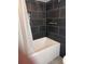 Bathroom with black tiled walls, white bathtub, shower and a shower curtain at 201 S Ocean Blvd. # 408, Myrtle Beach, SC 29577