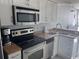 Clean kitchen with stainless steel appliances, white cabinets, and stone-look countertops at 201 S Ocean Blvd. # 408, Myrtle Beach, SC 29577