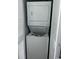 Stacked white washer and dryer in a closet with louvered doors at 201 S Ocean Blvd. # 408, Myrtle Beach, SC 29577