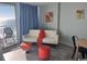 Bright condo living room with ocean view, balcony access, neutral sofa, and vibrant red accents at 201 S Ocean Blvd. # 408, Myrtle Beach, SC 29577