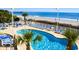 Exterior shot of pool area overlooking beach with lounge chairs and palm trees, offering relaxation and stunning views at 201 S Ocean Blvd. # 408, Myrtle Beach, SC 29577