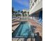 Beautiful pool deck with two jacuzzi spas, and a pool, surrounded by lounge chairs, umbrellas and palm trees at 201 S Ocean Blvd. # 408, Myrtle Beach, SC 29577