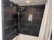 Bathroom shower with dark tile, rainfall showerhead, and a built-in shelf at 201 S Ocean Blvd. # 408, Myrtle Beach, SC 29577