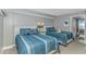 Bedroom featuring two beds with ensuite bathroom and beach decor at 201 S Ocean Blvd. # 616, Myrtle Beach, SC 29577