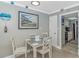 Charming dining area with a white table and chairs, complemented by a framed art and a glimpse of the kitchen at 201 S Ocean Blvd. # 616, Myrtle Beach, SC 29577
