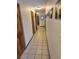 Long hallway featuring multiple wood doors, ceramic floors, and decorative wall art at 207 Double Eagle Dr. # E-1, Surfside Beach, SC 29575