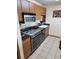 Compact kitchen showcasing sleek black appliances, wooden cabinets, and dark granite countertops at 207 Double Eagle Dr. # E-1, Surfside Beach, SC 29575