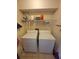 Functional laundry room equipped with a side-by-side washer and dryer under an open shelving at 207 Double Eagle Dr. # E-1, Surfside Beach, SC 29575