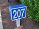 Blue sign displaying the house number 207 in a neighborhood setting at 207 Double Eagle Dr. # E-1, Surfside Beach, SC 29575