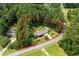 An aerial view of a single-Gathering home with lush surrounding greenery and property lines in bright red at 2135 Starduster Ln., Little River, SC 29566