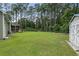 Well-maintained backyard showcasing a spacious lawn, mature trees, and a storage shed at 2135 Starduster Ln., Little River, SC 29566