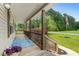 View of covered front porch with blue patterned rug, porch railing, and view to yard at 2135 Starduster Ln., Little River, SC 29566