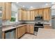 Close up of kitchen featuring stainless steel appliances, wood cabinets and double basin sink at 2135 Starduster Ln., Little River, SC 29566