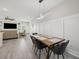 Open-concept dining area with modern lighting, flowing into a spacious living room and kitchen at 2143 Stonecrest Dr. Nw, Calabash, NC 28467