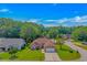 Aerial view of a traditional brick home with lush landscaping and a long driveway in a peaceful, tree-lined neighborhood at 2454 Glen Dr., Little River, SC 29566
