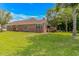 Spacious backyard showcasing the home's brick exterior, large windows, and a welcoming covered patio perfect for outdoor living at 2454 Glen Dr., Little River, SC 29566