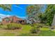 View of the house from the backyard showing a well-manicured lawn, landscaped garden beds, and a cozy, covered patio at 2454 Glen Dr., Little River, SC 29566