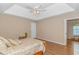 A cozy bedroom featuring a tray ceiling, ceiling fan, and wood-look flooring at 2454 Glen Dr., Little River, SC 29566