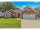 Charming brick home featuring an attached two-car garage and well-manicured lawn at 2454 Glen Dr., Little River, SC 29566