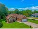 Well-maintained brick home with a two-car garage, lush lawn, and mature trees under a bright blue sky at 2454 Glen Dr., Little River, SC 29566