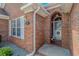 Charming brick home entrance with an arched doorway and well-maintained landscaping at 2454 Glen Dr., Little River, SC 29566